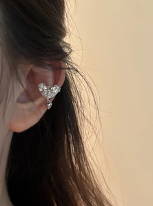 Vue détaillée d'une manchette d'oreille en cœur et croix en zircon sur un modèle