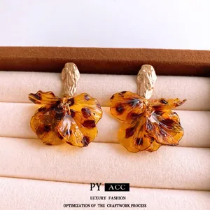 Vintage tortoiseshell acrylic petal earrings with golden textured metal base in a box