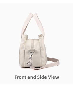 Detail of off-white canvas tote showing side D-ring, lobster clasp, and zipper closure