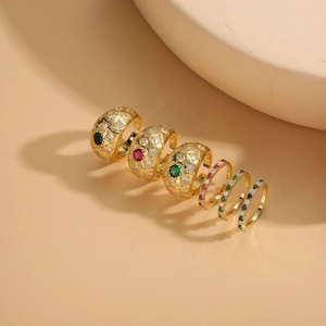 Detailed view of luxury gold-plated rings set with vibrant red blue and green gemstones
