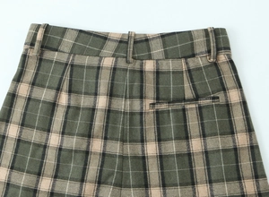 Détail du pantalon droit à carreaux vert avec passants de ceinture et couture fine