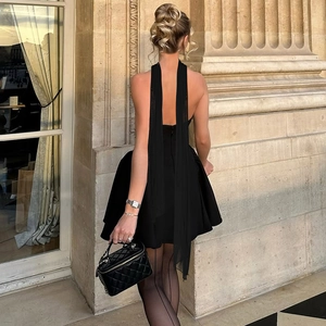 Detail of elegant black backless dress with zipper and quilted leather chain handbag