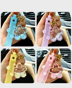 Detailed view showing four colors of Sakura quicksand acrylic keychains with liquid flower charms