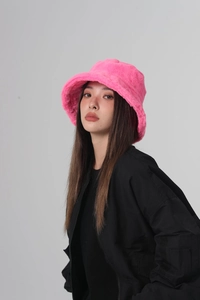 Detail of soft bright pink plush bucket hat showing fluffy faux fur texture and vibrant color
