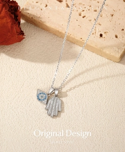Detailed shot of S925 sterling silver Hamsa hand and Evil Eye pendant with pave zircons
