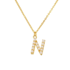 Detailed close-up of golden necklace with letter N pendant inlaid with small white pearls