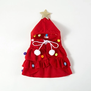 Detail of red Christmas tree pet cloak featuring colorful pom-poms and gold star top