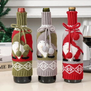 Close-up of knitted Christmas gnome wine bottle covers with decorative pom poms and textures