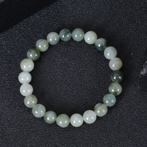 Detailed top view of natural green and white quartz beaded bracelet on black texture