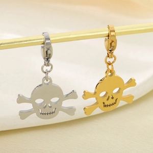 Detailed macro view of gold and silver skull pendants with lobster clasp connectors