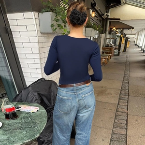 Détail du haut en tricot bleu marine à manches longues avec une coupe ajustée élégante