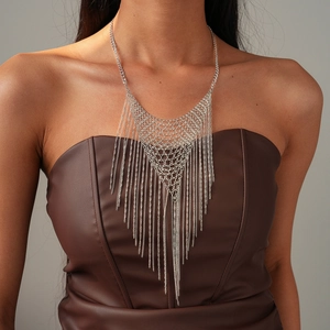 Détail du collier en maille argentée avec franges en triangle sur une tenue de mannequin