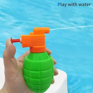 Green grenade-shaped water gun toy held over a blue pool for summer outdoor fun