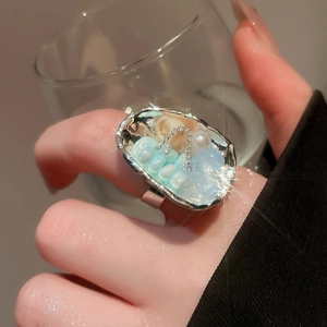 Detail shot of a silver shell bead open ring with pearls on a model hand
