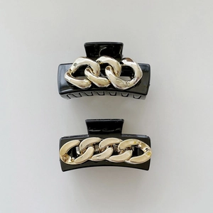 Elegant black hair claws with vintage gold chain designs set against white background