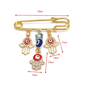 Detailed size view of a golden Hamsa hand safety pin brooch with 50mm length and blue beads