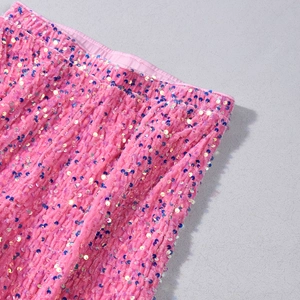 Détail des paillettes roses et bleues sur un pantalon large pour la fête