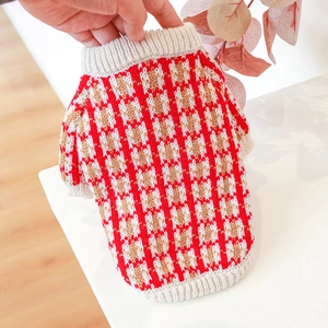 Close-up of red and brown plaid knit pet sweater with ribbed collar and hem detail