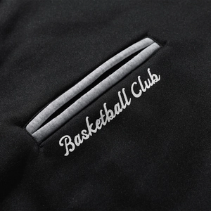 Detail of Basketball Club embroidery and grey knit piping on black sports jacket