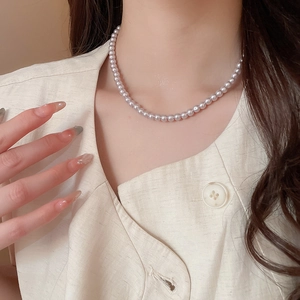 Detail of 4-6mm light purple pearl necklace on model showing elegant French style