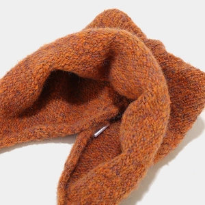 Close-up of twisted knit texture and warm orange-brown chunky yarn pattern