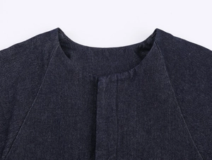 Detail von dunkelblauem Denim-Jackenausschnitt und Raglanärmeln auf weißem Hintergrund