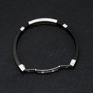 Détail d'un bracelet en silicone noir avec plaque en acier inoxydable et boucle déployante