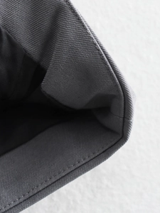 Détail macro de la texture du tissu gris foncé avec couture précise et doublure noire