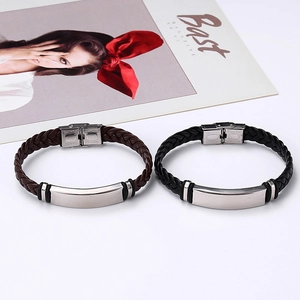 Close-up of black and brown braided leather bracelets with polished stainless steel clasp