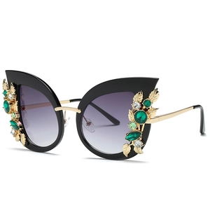 Fashionable cat eye sunglasses with diamond-encrusted black frames and green crystals