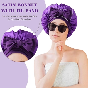 Detailed macro view of purple satin bonnet featuring an adjustable tie band and large bow