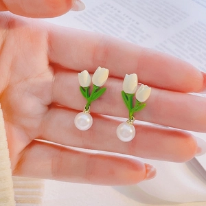 Detailed close-up of a tulip flower earring featuring a white bud and round pearl drop