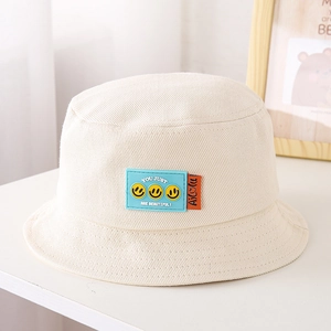 Dettaglio cappello pescatore panna per bambini con patch sorriso in silicone blu