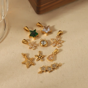 Pendentifs en acier titane doré avec zircons verts sur fond de tissu beige élégant