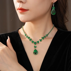 Dettaglio di modella con set di collana e orecchini a goccia in zircone verde e argento