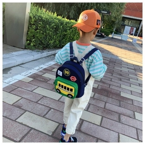 Detail of blue school bus backpack for kids with green pocket and traffic patterns
