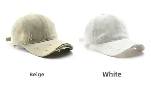 Close-up of distressed cotton baseball caps with vintage frayed holes in beige and white