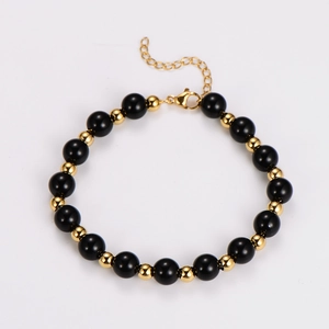 Detail of beaded bracelet featuring tiger eye obsidian beads with a gold lobster clasp