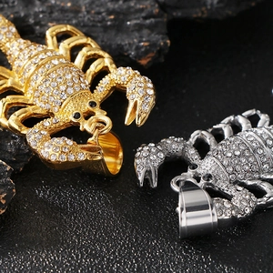 Vue macro de pendentifs scorpion glacés avec finitions or et argent et strass transparents