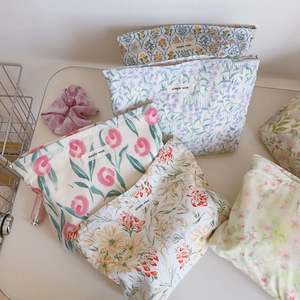 Vue détaillée de trousses à maquillage en coton avec motifs floraux et fermetures