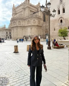 Vista detallada de traje blazer de mezclilla oscura con hombreras y botones dorados