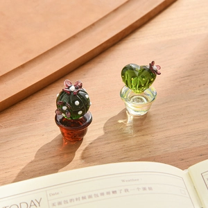 Handcrafted mini green glass cactus figurines with cute polka dots on wooden table