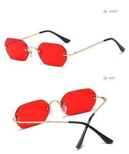 Detalle de gafas de sol octogonales rojas sin montura con patillas de metal dorado