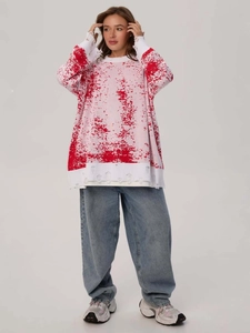 Oversized distressed knit sweater with red gradient splatter pattern and ripped details