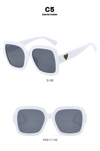 Detailansicht der quadratischen weißen Sonnenbrille mit schickem schwarzem Herz am Bügel