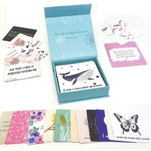 Flat lay of blue gift box with motivational quote cards featuring whales and flowers