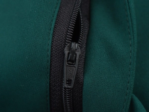 Close-up detail of smooth black zipper on dark green woven fabric of dress trousers
