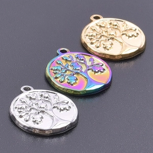 Detailed view of tree of life pendants in gold, rainbow, and silver stainless steel