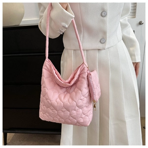 Close-up of pink heart-quilted tote bag with a small matching round coin purse