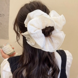 Elegant oversized white pleated ruffle hair scrunchie styled in a chic half-up hair look